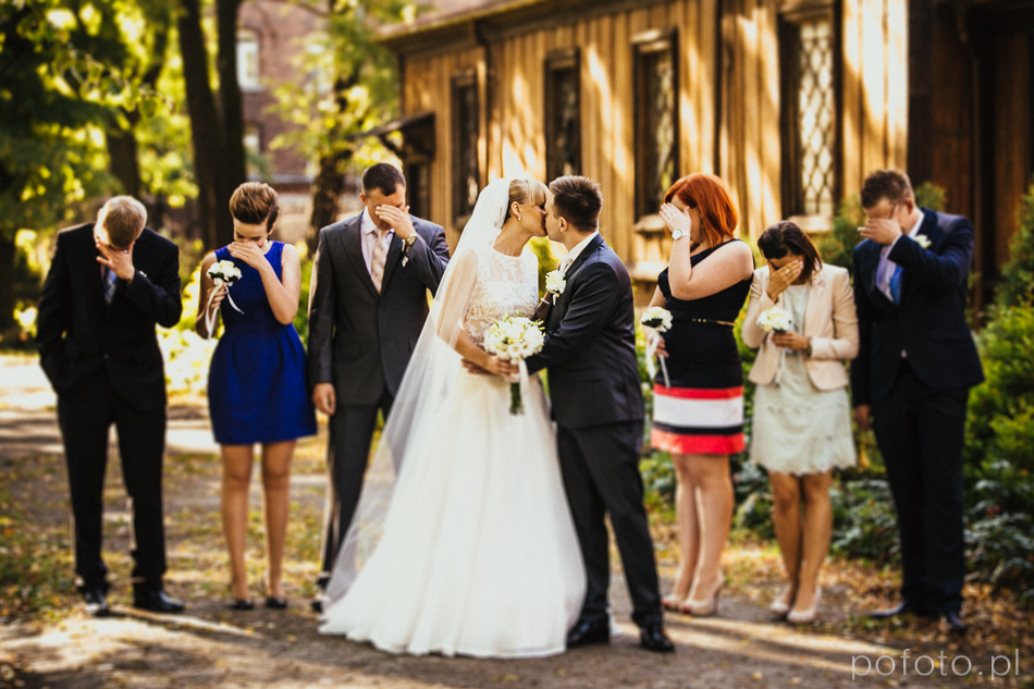 pocałunek pary przed ceremonią ślubną w tle świadkowie zakrywają oczy